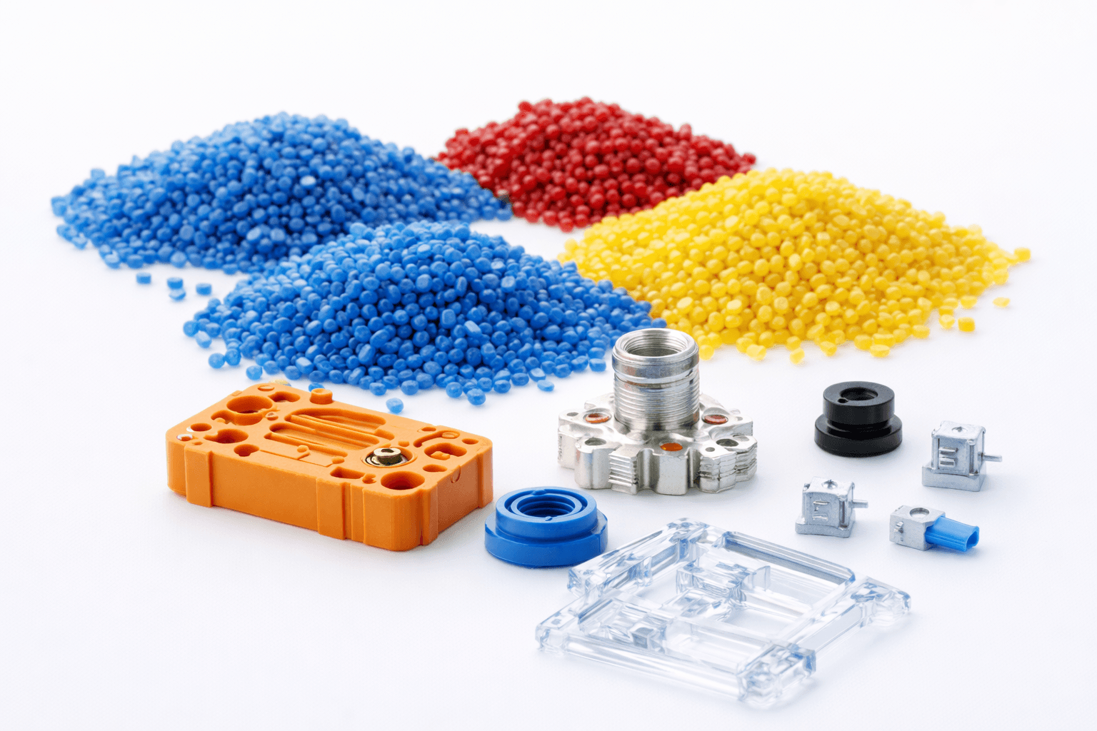 Colored engineering resin pellets beside molded plastic parts and metal inserts