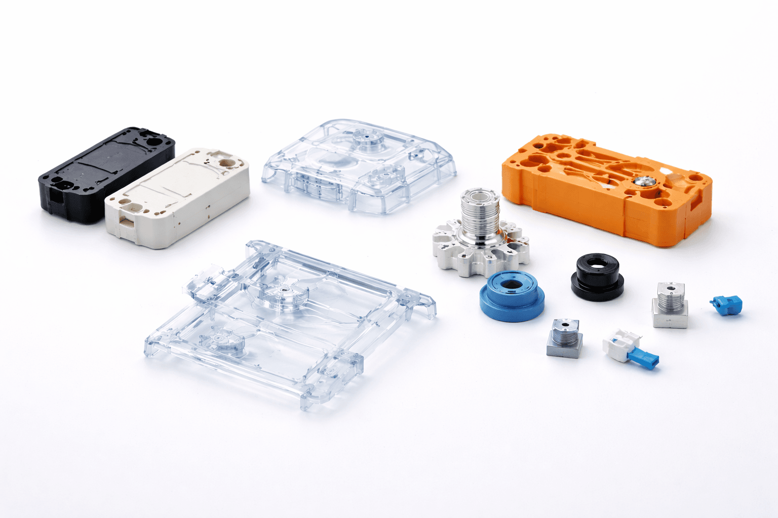 Molded plastic housings, clear frames, an orange block, and small threaded metal parts