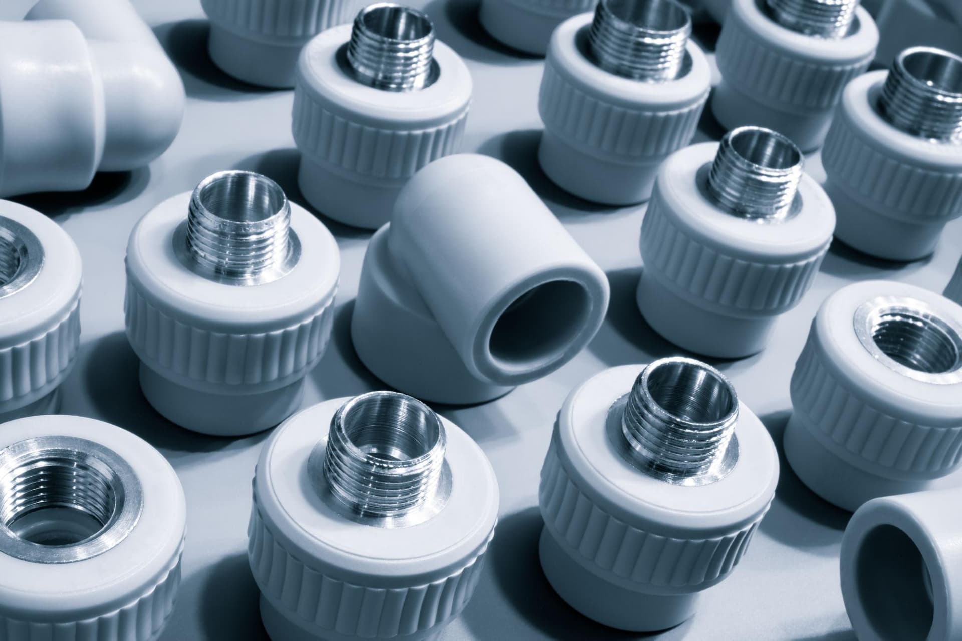 Gray plastic pipe fittings and elbows with threaded metal inserts molded in